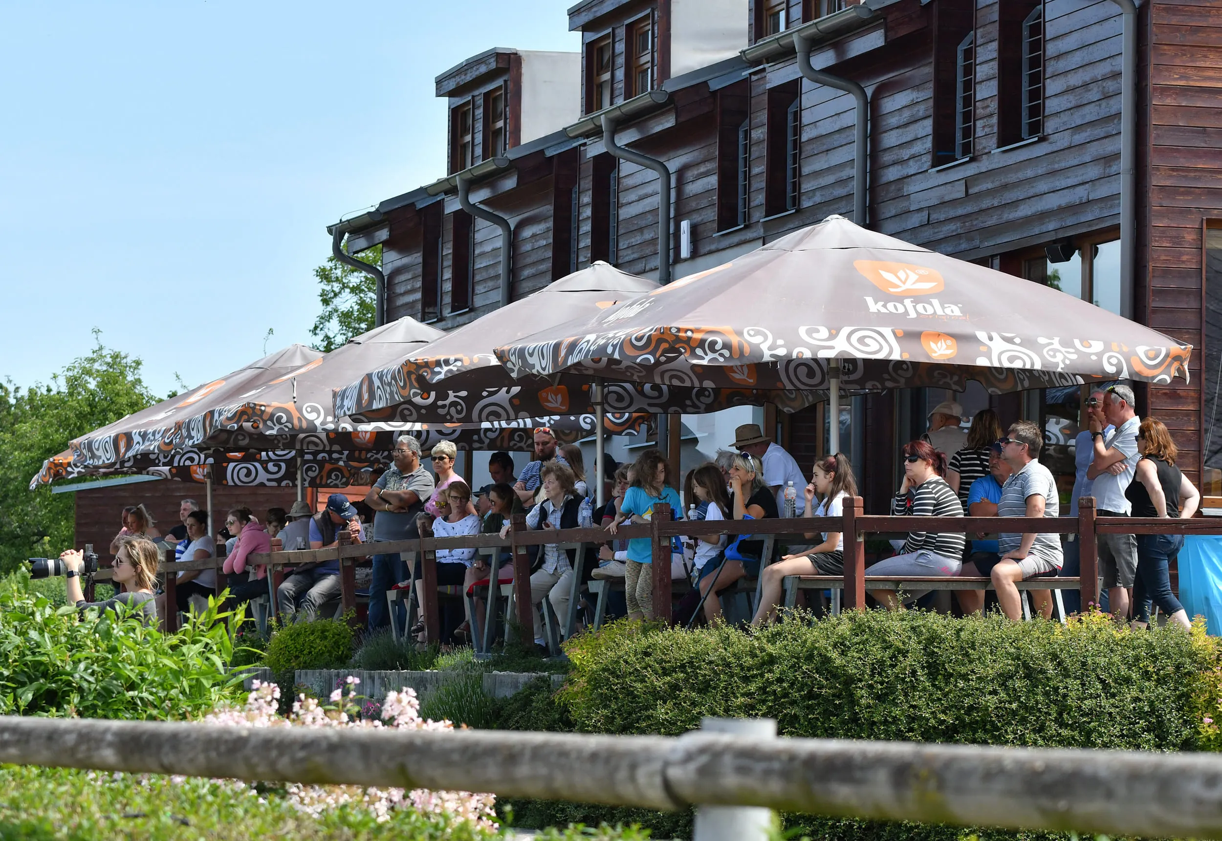 Terasa penzionu se slunečníky nad kolbištěm
